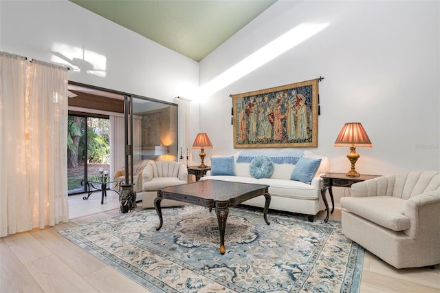 living room featuring light wood-type flooring and high vaulted ceiling