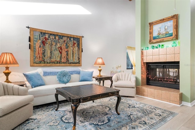 living area featuring a tiled fireplace and light wood-type flooring