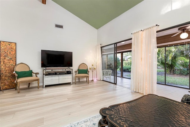 interior space with ceiling fan, high vaulted ceiling, and light hardwood / wood-style floors