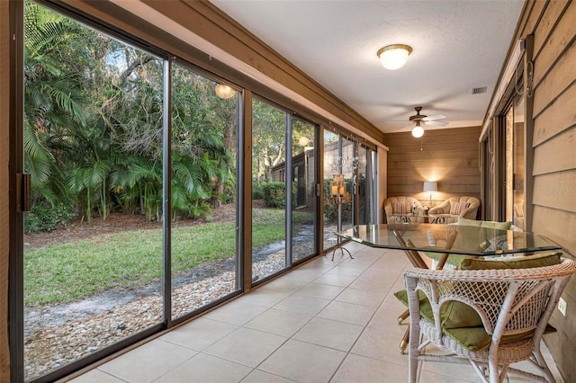 unfurnished sunroom with ceiling fan