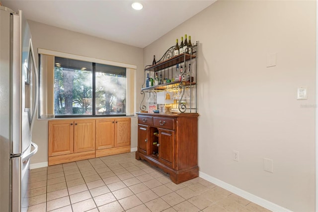 interior space featuring light tile patterned floors and stainless steel refrigerator with ice dispenser