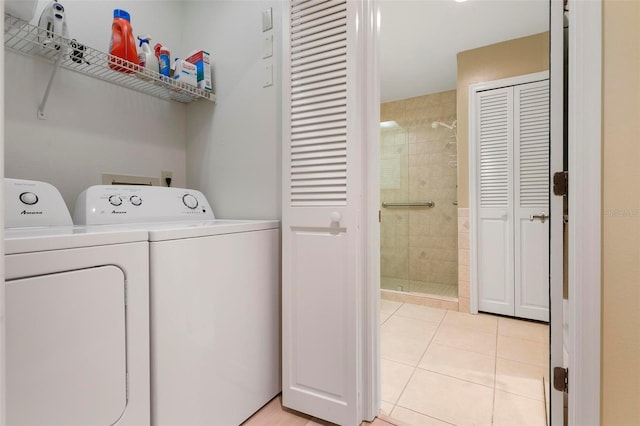 clothes washing area with washer and clothes dryer and light tile patterned floors