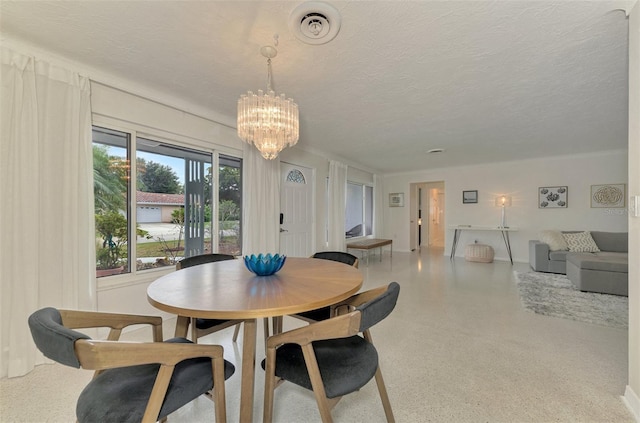 dining space with a textured ceiling and an inviting chandelier