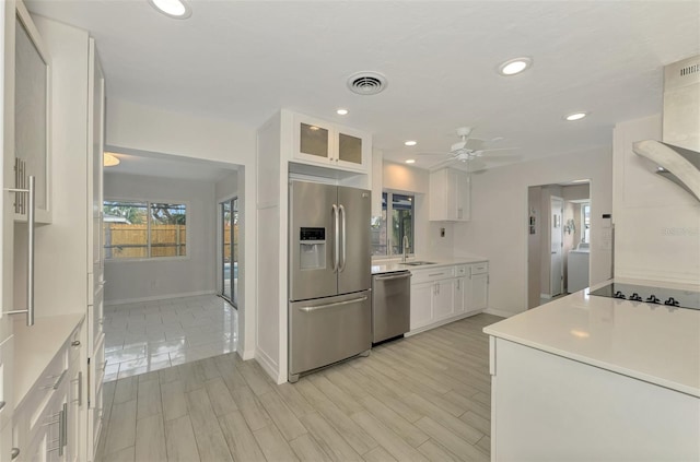 kitchen with white cabinetry, sink, ceiling fan, appliances with stainless steel finishes, and light wood-type flooring