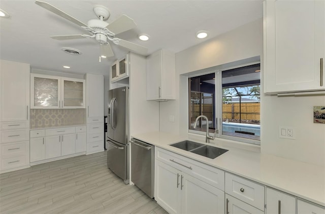 kitchen with white cabinets, sink, light hardwood / wood-style flooring, ceiling fan, and stainless steel appliances