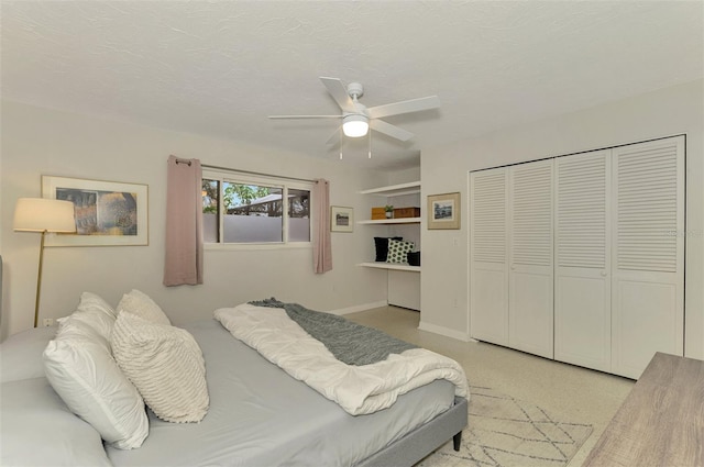 carpeted bedroom with a textured ceiling, a closet, and ceiling fan