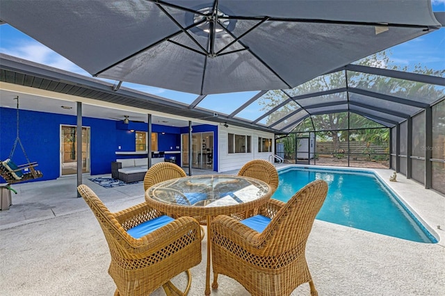 view of pool with a patio area, ceiling fan, and glass enclosure