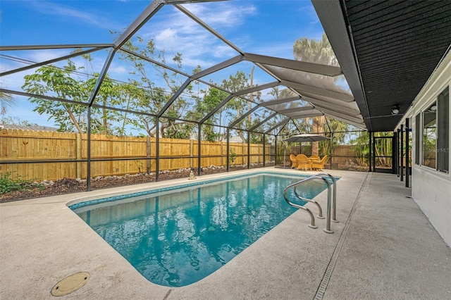 view of pool with glass enclosure and a patio