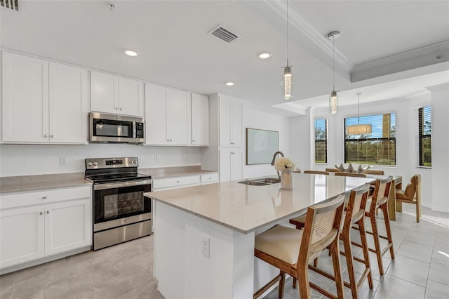 kitchen featuring decorative light fixtures, sink, white cabinetry, an island with sink, and stainless steel appliances