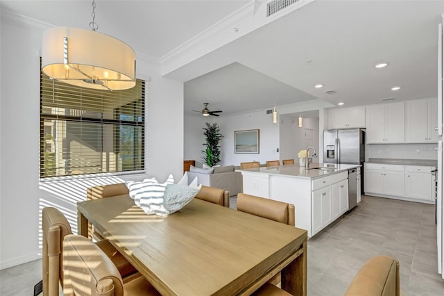 dining room featuring ceiling fan, sink, and crown molding