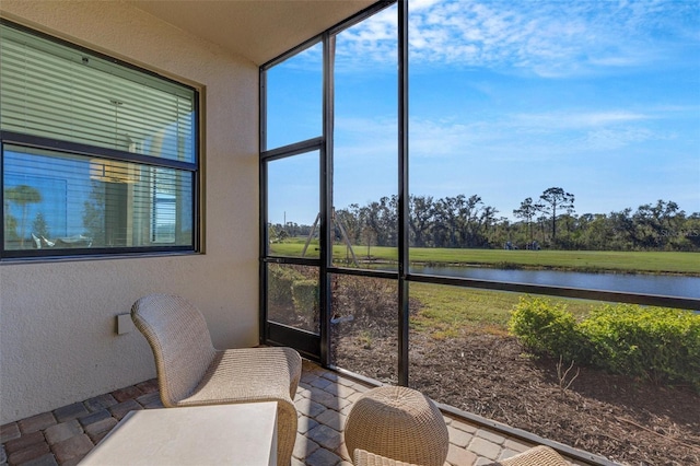 sunroom / solarium featuring a wealth of natural light and a water view