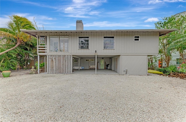 back of property with a carport and a sunroom