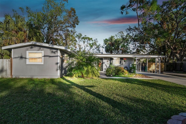 view of front of house featuring a carport and a lawn