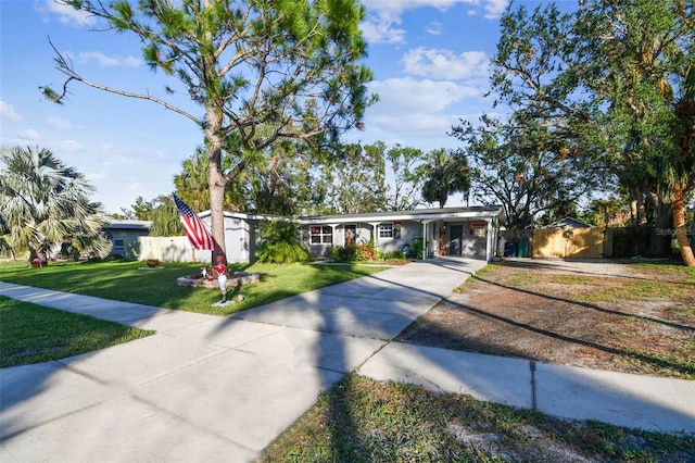 ranch-style house featuring a front lawn and a carport