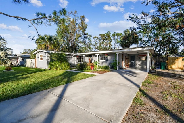 ranch-style home featuring a front lawn and a carport