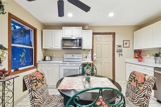 kitchen featuring ceiling fan, white cabinets, light tile patterned floors, and appliances with stainless steel finishes