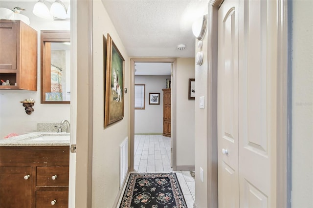 hallway featuring sink and a textured ceiling