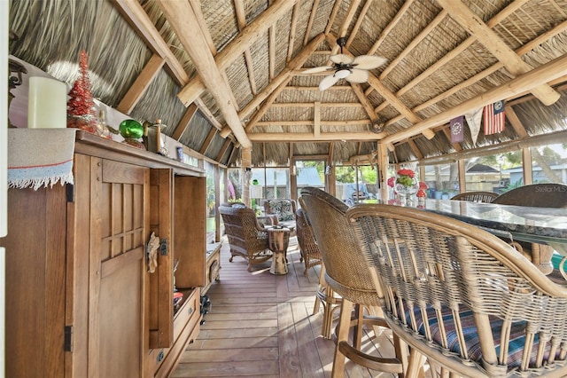 sunroom / solarium featuring vaulted ceiling with beams, ceiling fan, and wooden ceiling