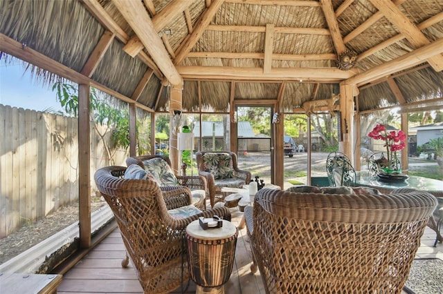 sunroom / solarium featuring vaulted ceiling with beams