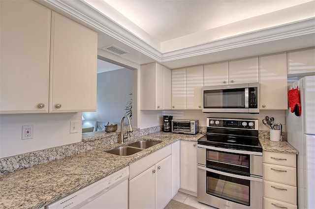 kitchen featuring appliances with stainless steel finishes, sink, light tile patterned floors, and light stone counters