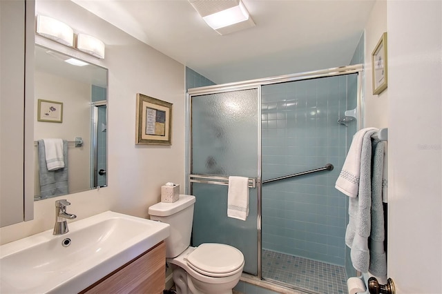 bathroom featuring vanity, a shower with shower door, and toilet