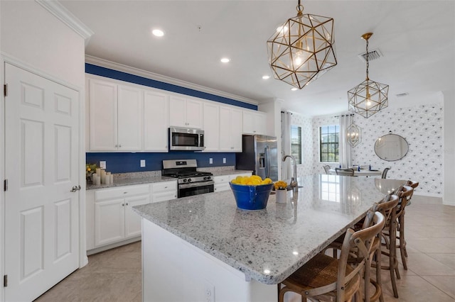 kitchen with pendant lighting, a large island, a breakfast bar area, stainless steel appliances, and white cabinets