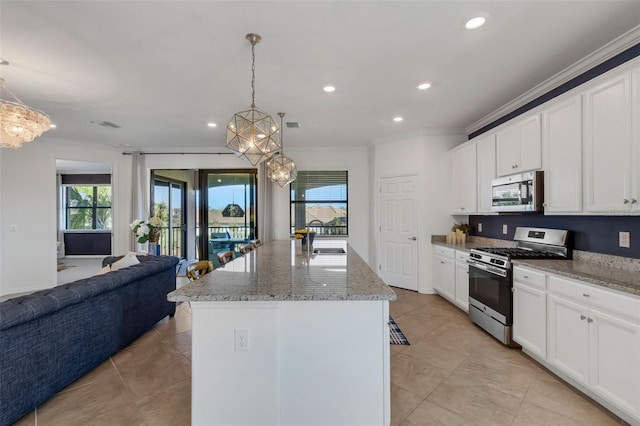 kitchen with stainless steel appliances, a chandelier, a center island with sink, and hanging light fixtures