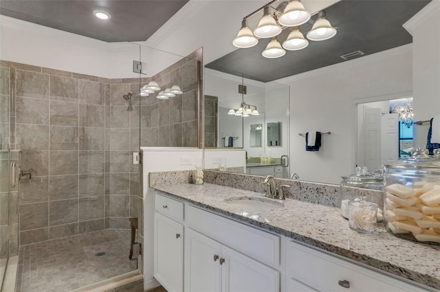 bathroom featuring an enclosed shower, vanity, and ornamental molding