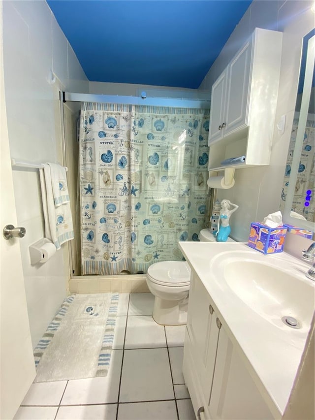 bathroom featuring tile patterned flooring, vanity, curtained shower, and toilet