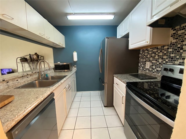 kitchen with sink, stainless steel appliances, light tile patterned floors, decorative backsplash, and white cabinets