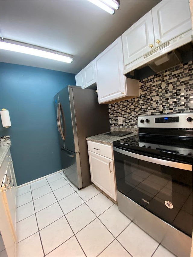 kitchen with tasteful backsplash, premium range hood, stainless steel appliances, light tile patterned floors, and white cabinets