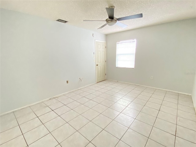 tiled spare room featuring ceiling fan and a textured ceiling