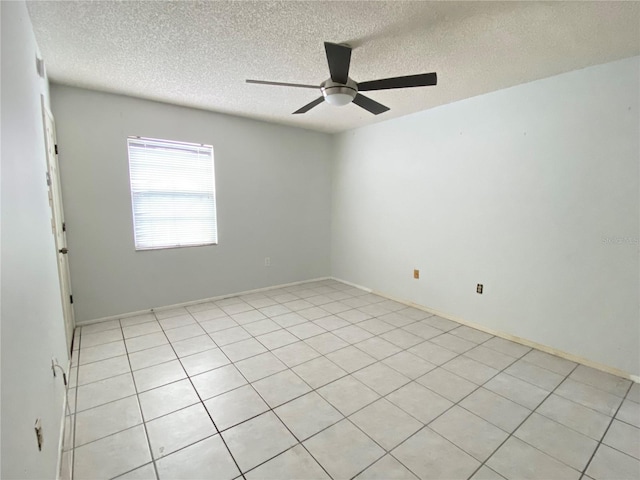 tiled empty room with ceiling fan and a textured ceiling