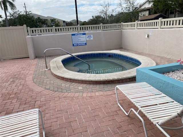 view of swimming pool featuring a patio area and a hot tub