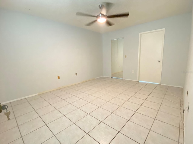 tiled empty room featuring ceiling fan