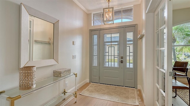 doorway with light hardwood / wood-style floors and crown molding