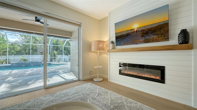 doorway with a fireplace, light hardwood / wood-style flooring, and ceiling fan