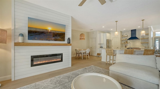 living room featuring ceiling fan and light hardwood / wood-style flooring