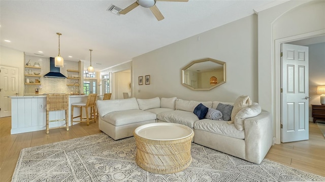 living room with ceiling fan and light hardwood / wood-style flooring