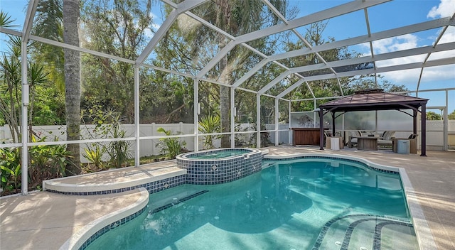 view of swimming pool with an in ground hot tub, a gazebo, a patio, and glass enclosure