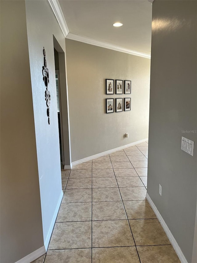 corridor featuring light tile patterned floors and crown molding