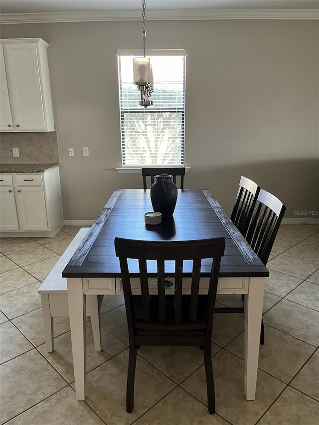 dining room featuring light tile patterned floors and crown molding