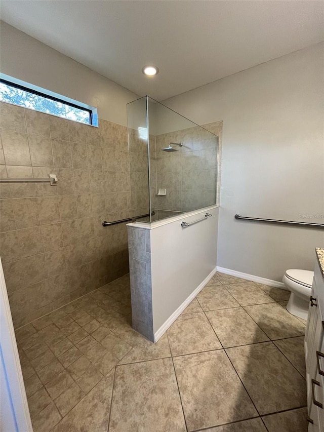 bathroom featuring a tile shower, tile patterned flooring, and vanity