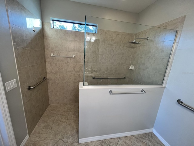 bathroom with a tile shower and tile patterned flooring