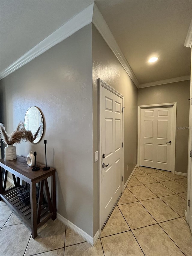 hallway featuring light tile patterned floors and crown molding