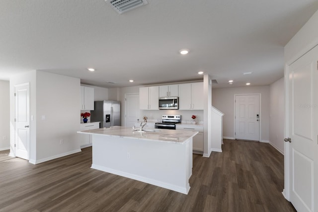 kitchen featuring white cabinetry, sink, stainless steel appliances, dark hardwood / wood-style flooring, and an island with sink