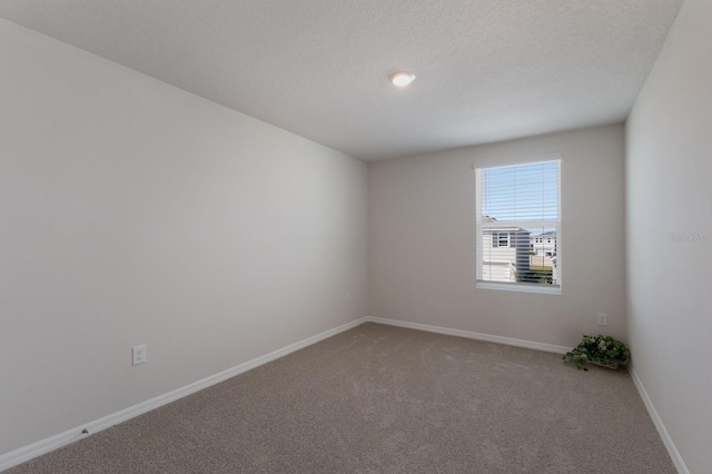 carpeted spare room featuring a textured ceiling