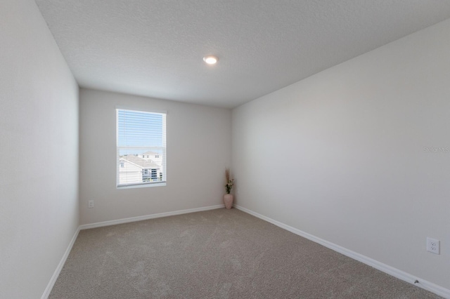 carpeted spare room featuring a textured ceiling