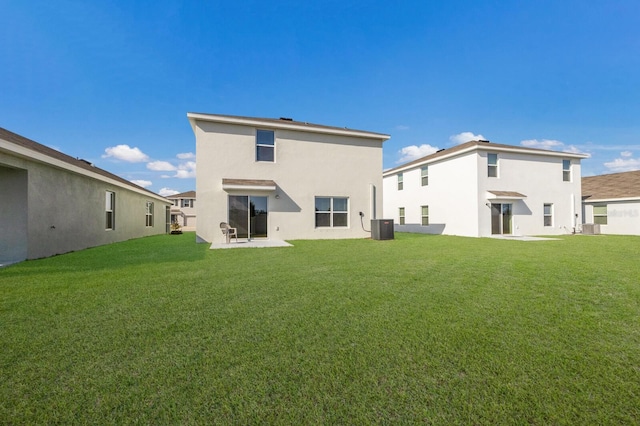 rear view of property featuring central air condition unit, a yard, and a patio