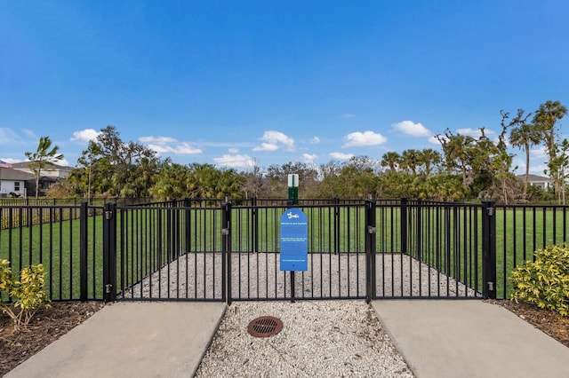 view of gate with a lawn